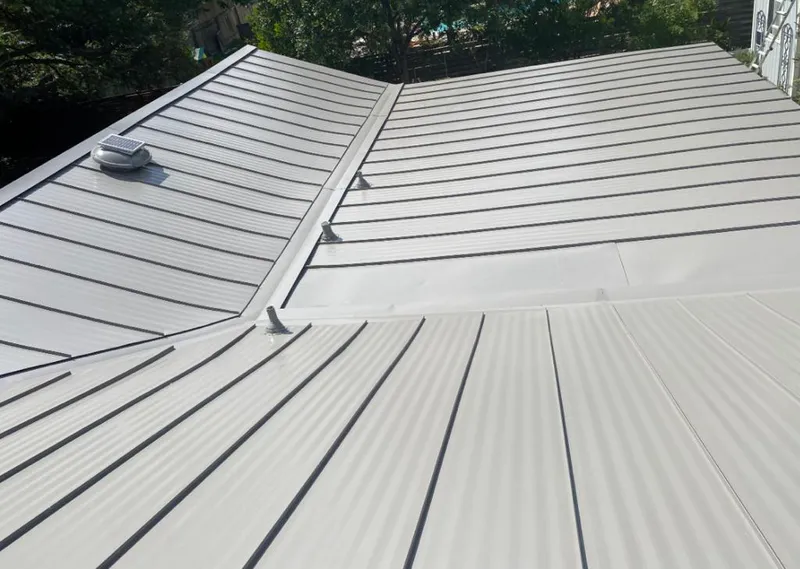 Solar attic fan installed on a metal roof for Roof Ventilation in Plainview